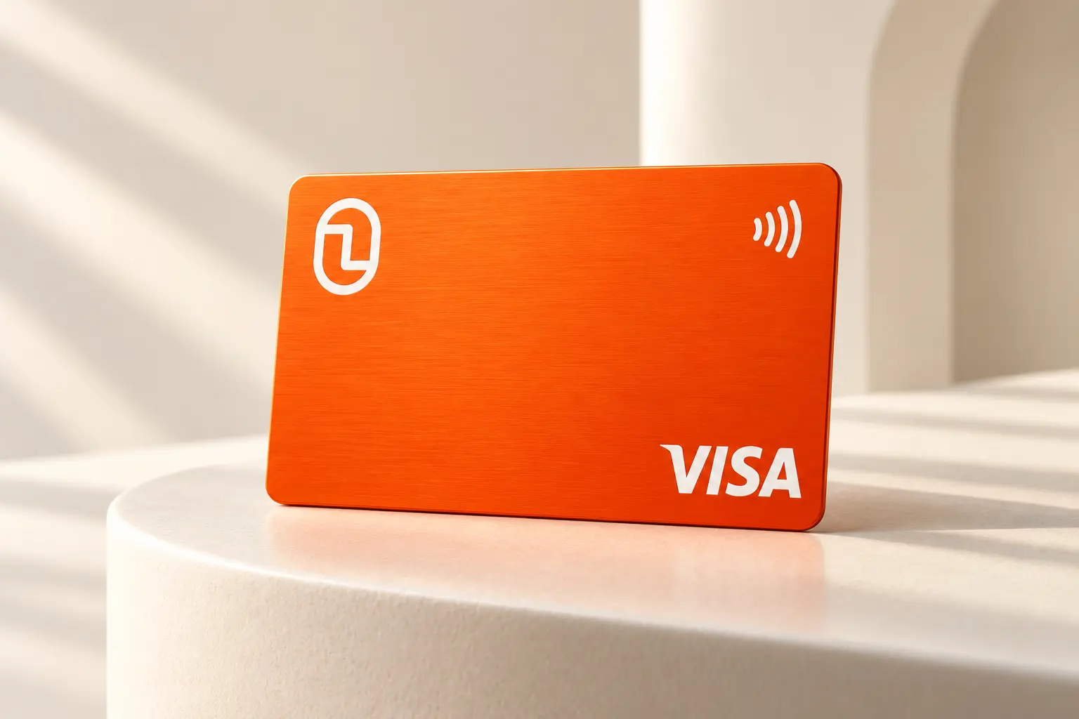 Single orange Finyon Pay Visa card in a warm studio setting