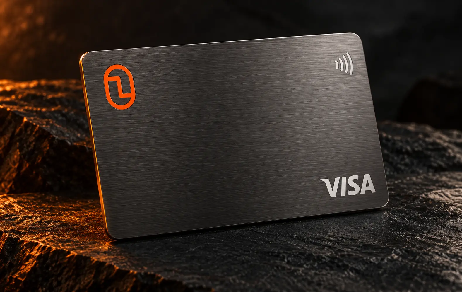 Illustrative dark metal Finyon Pay Visa card with orange Finyon mark